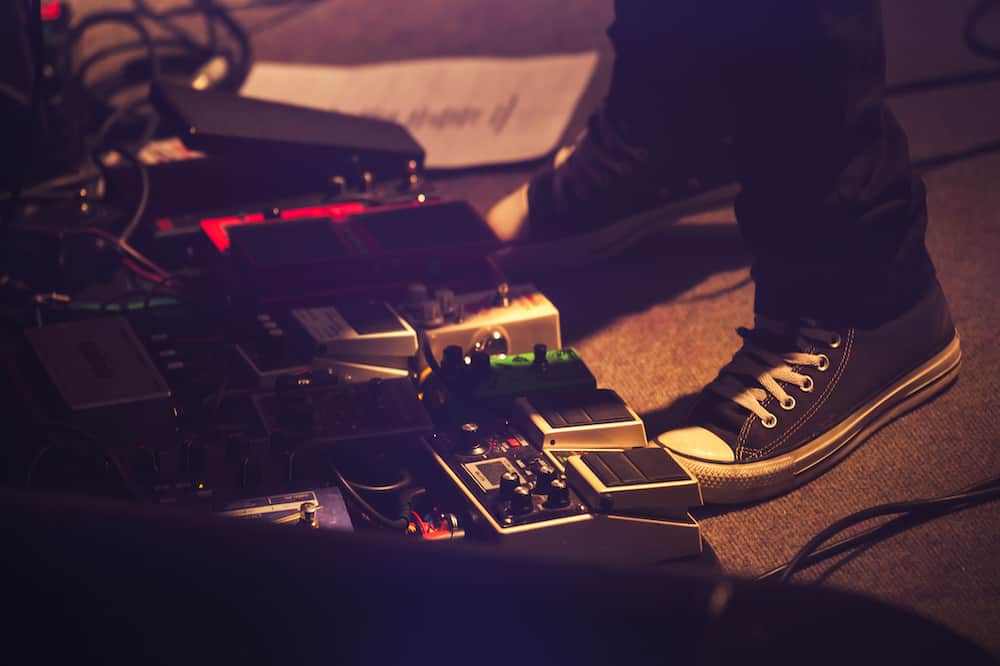 Electric guitar players legs on a stage