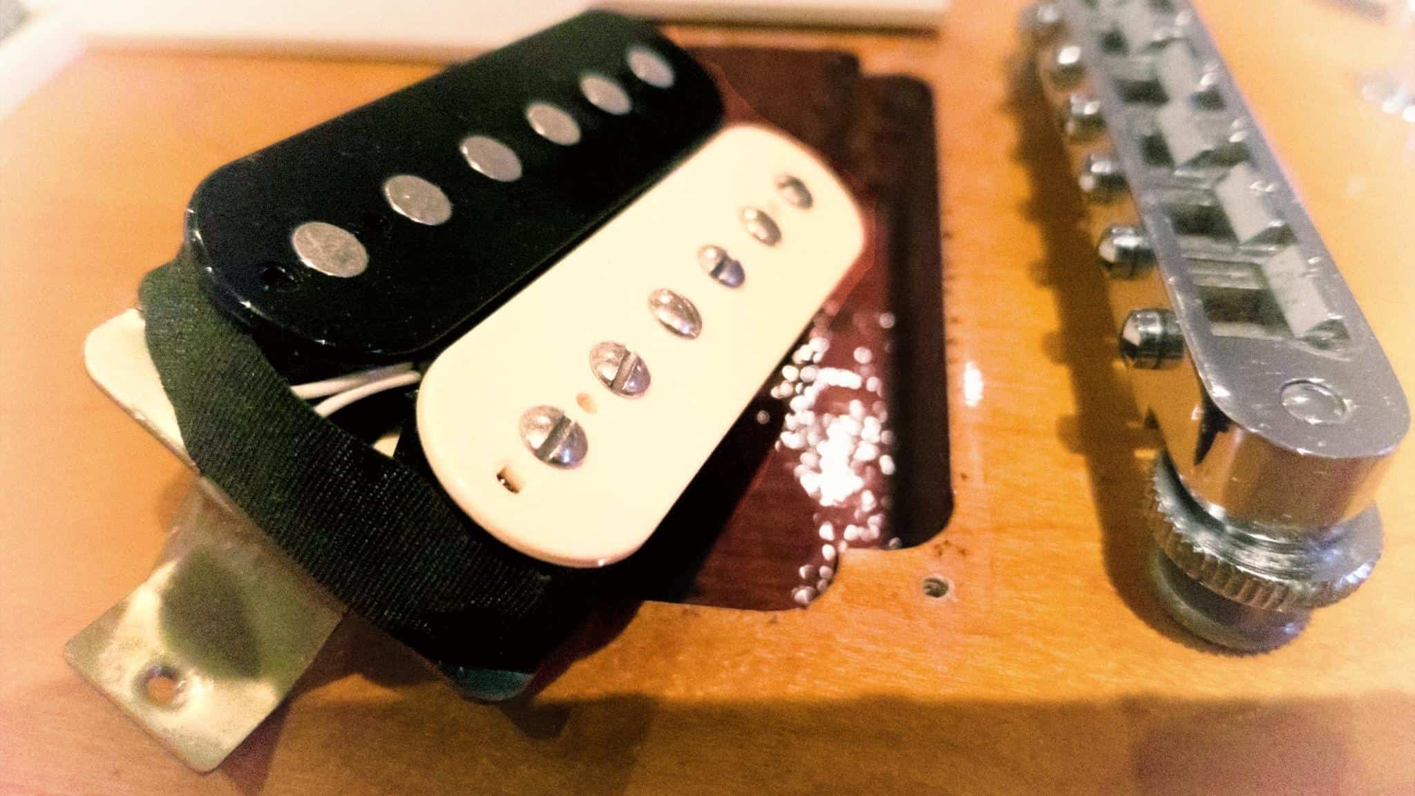 Humbucker pickup getting fitted into a guitar