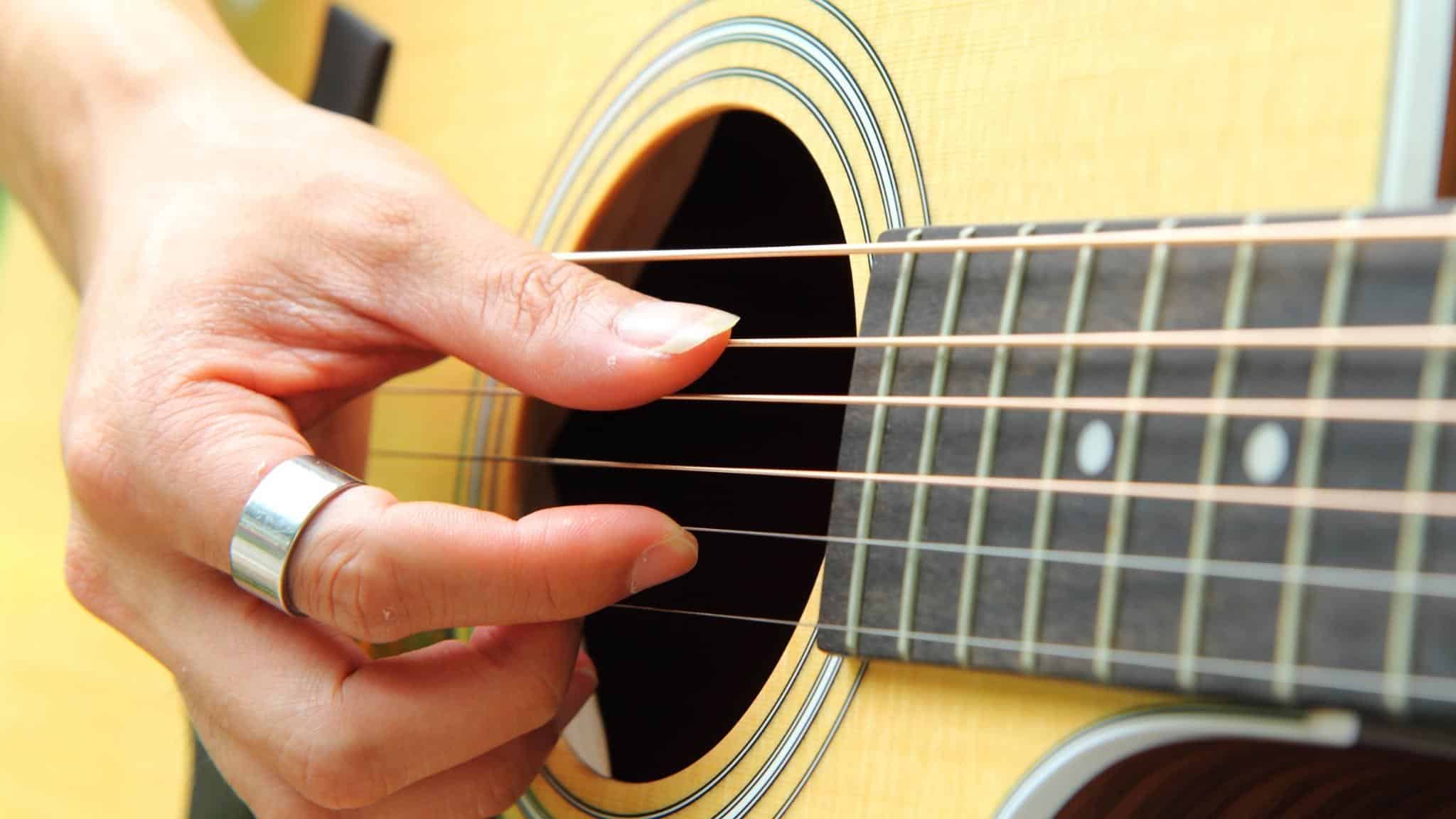 tocar con los dedos una guitarra